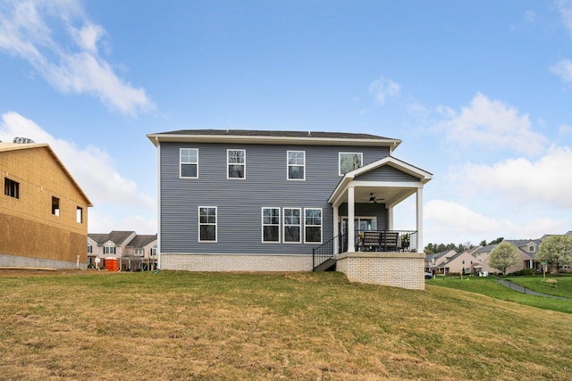 rear view of house featuring ceiling fan, a lawn, stairs, and a porch