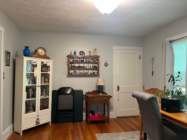 home office featuring wood finished floors and a textured ceiling