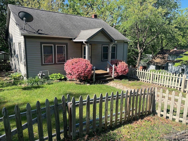 bungalow-style home featuring a chimney and roof with shingles