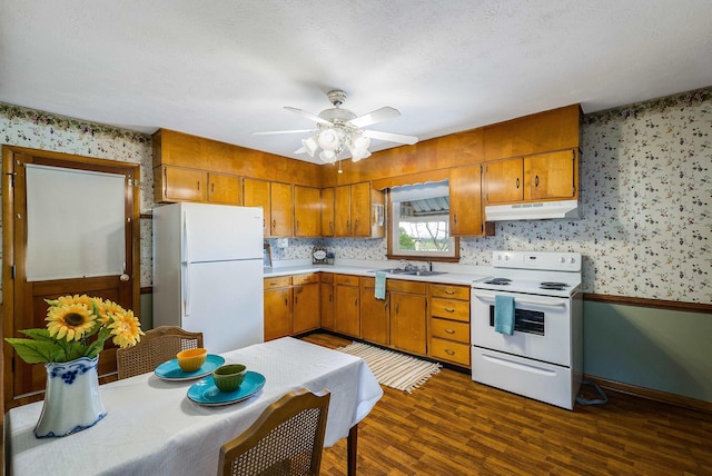 390 Frontier Dr, Staunton, VA 24401 - kitchen with white appliances, under cabinet range hood, wallpapered walls, a sink, and brown cabinets