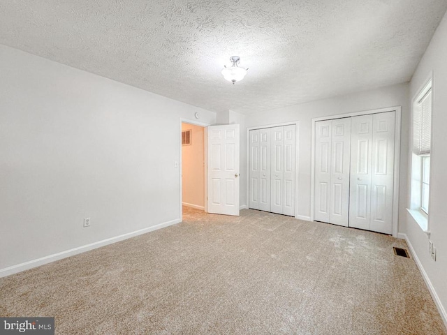 4110 Englandtown Rd, Fredericksburg, VA 22408 - unfurnished bedroom featuring multiple closets, carpet, baseboards, and a textured ceiling