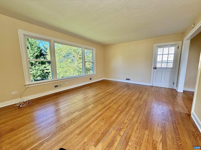 405 Moseley Dr, Charlottesville, VA 22903 - spare room featuring light wood-style floors, baseboards, and a textured ceiling