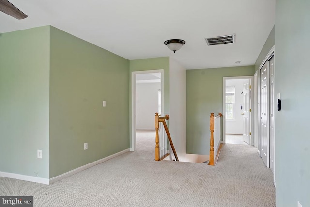corridor featuring an upstairs landing, carpet floors, and baseboards
