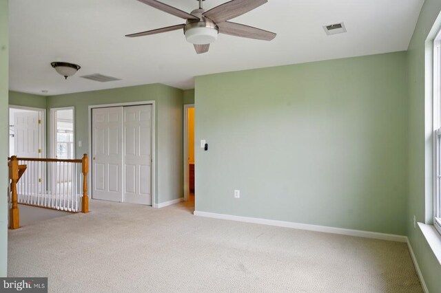 empty room with carpet, a ceiling fan, and baseboards