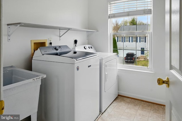 clothes washing area featuring washer and clothes dryer and baseboards