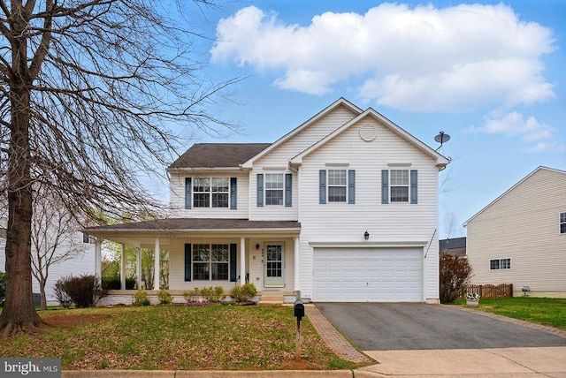 traditional home featuring asphalt driveway, a garage, a porch, and a front yard