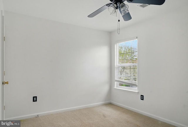 unfurnished room with a ceiling fan, baseboards, and light colored carpet
