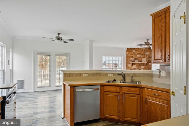kitchen with stainless steel dishwasher, ceiling fan, a sink, a peninsula, and ornamental molding