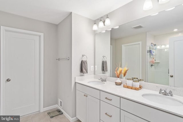 full bathroom with a shower stall, tile patterned floors, double vanity, and baseboards