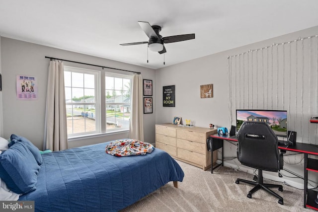 carpeted bedroom featuring an office area and ceiling fan