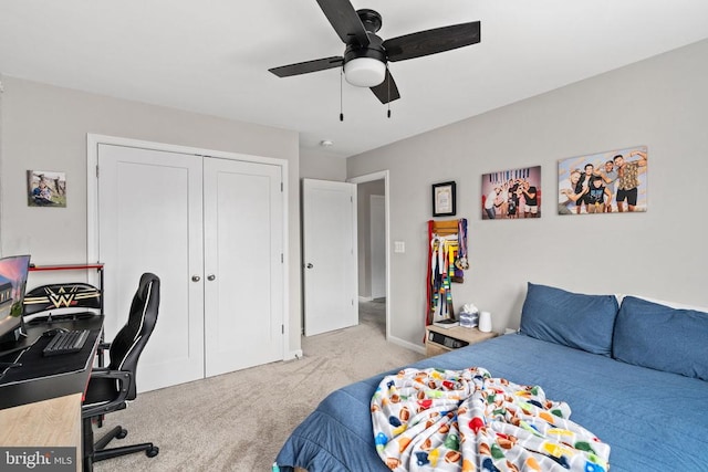 carpeted bedroom with a desk, a closet, a ceiling fan, and baseboards