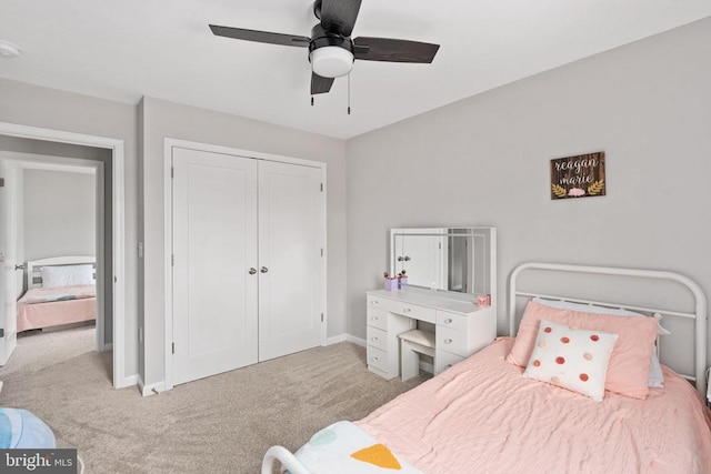 carpeted bedroom featuring a closet, baseboards, and ceiling fan