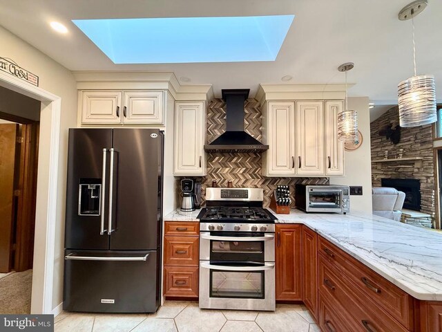 778 Overton Dr, Mineral, VA 23117 - kitchen with high end refrigerator, range with two ovens, a skylight, and wall chimney range hood