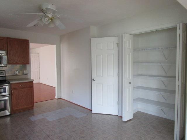 384 Hickory Grove Cir, Harrisonburg, VA 22801 - kitchen featuring appliances with stainless steel finishes, a ceiling fan, brown cabinetry, backsplash, and tile patterned floors