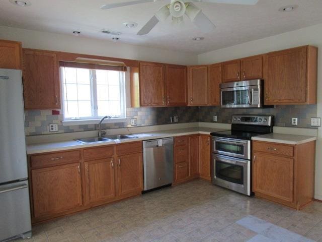 384 Hickory Grove Cir, Harrisonburg, VA 22801 - kitchen with stainless steel appliances, a sink, brown cabinets, and light countertops