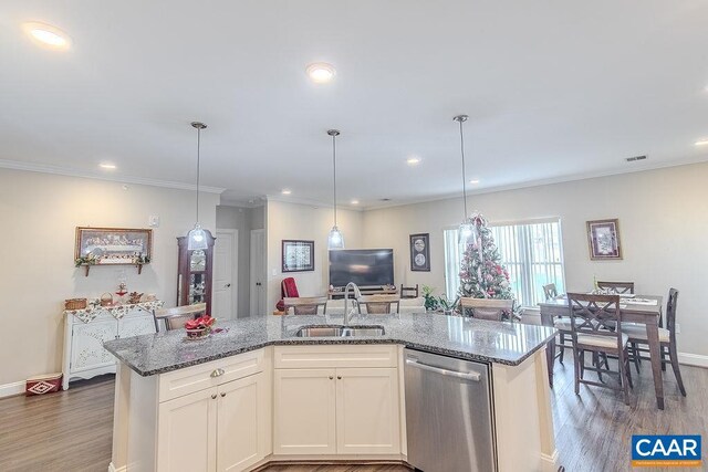 kitchen with stone counters, wood finished floors, a sink, open floor plan, and stainless steel dishwasher