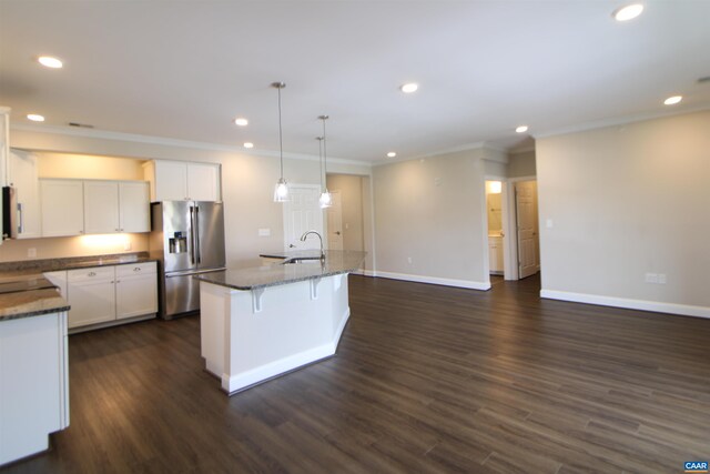 kitchen with stainless steel refrigerator with ice dispenser, crown molding, a sink, baseboards, and recessed lighting