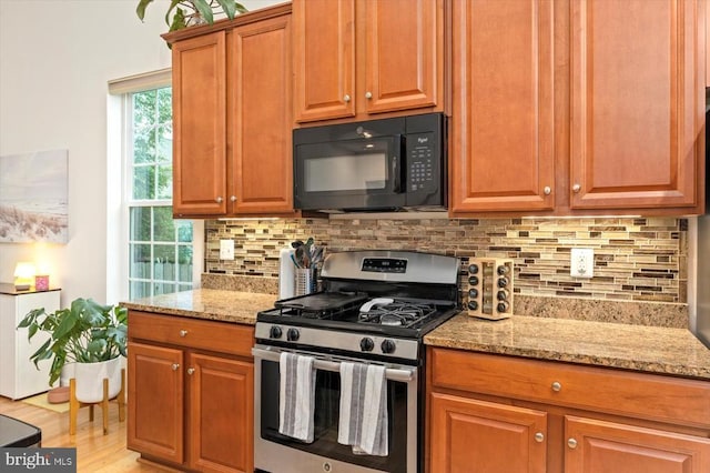 12122 Majestic Pl, Culpeper, VA 22701 - kitchen with gas stove, black microwave, decorative backsplash, and light stone counters