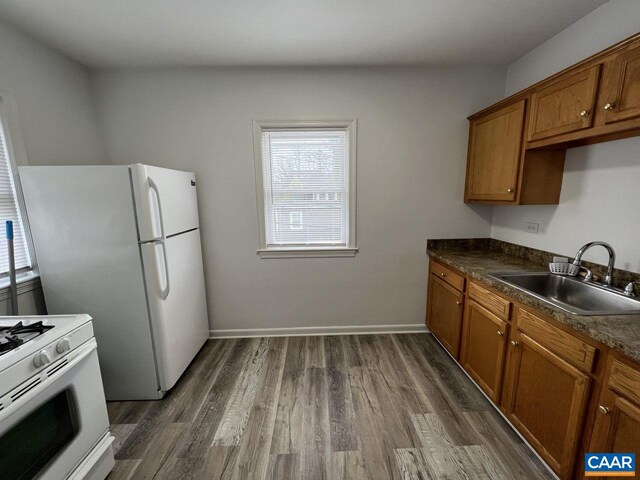 301 7th St SW, Charlottesville, VA 22903 - kitchen with a sink, brown cabinetry, white appliances, dark wood finished floors, and plenty of natural light