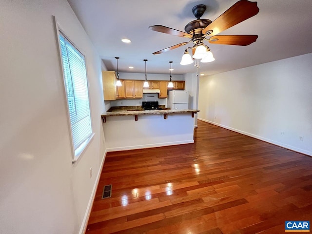 301 7th St SW, Charlottesville, VA 22903 - kitchen with freestanding refrigerator, a peninsula, dark wood-style flooring, and baseboards