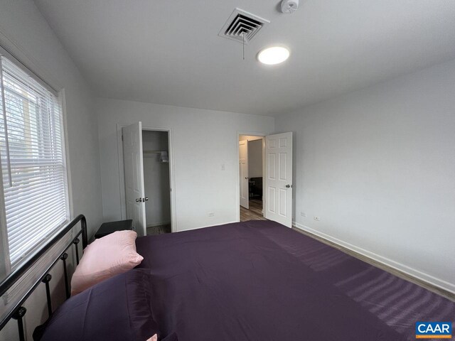 301 7th St SW, Charlottesville, VA 22903 - bedroom featuring a walk in closet, baseboards, a closet, and visible vents