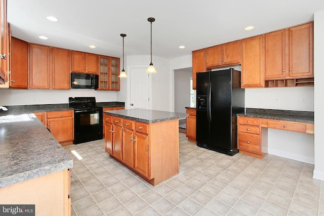 kitchen with built in desk, a kitchen island, black appliances, and recessed lighting