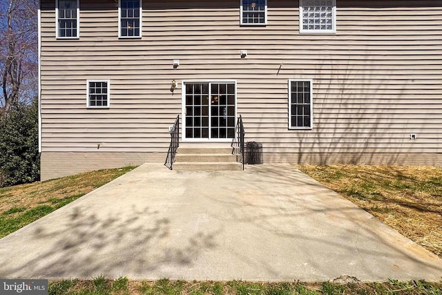 rear view of property with entry steps and a patio