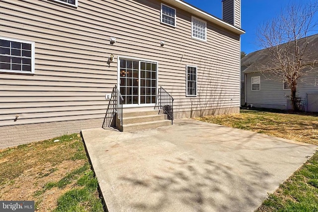 rear view of property with a patio area, a chimney, and entry steps