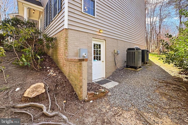 view of side of property with central air condition unit and brick siding