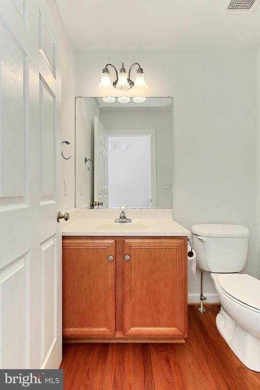 bathroom with toilet, baseboards, vanity, and wood finished floors