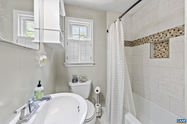 full bathroom featuring a sink, healthy amount of natural light, toilet, and shower / bathtub combination with curtain