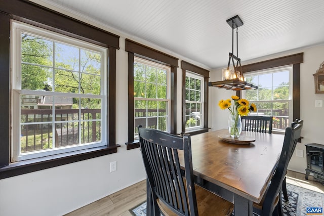 dining area with a chandelier, plenty of natural light, light wood-style flooring, and ornamental molding