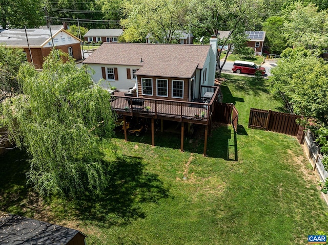 back of property featuring a deck, roof with shingles, and a chimney