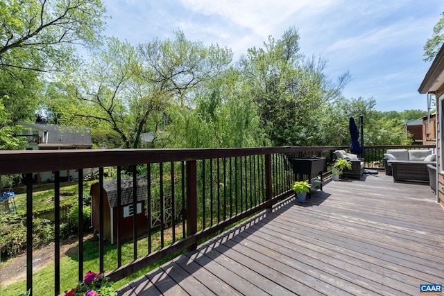 wooden deck with a shed, an outdoor structure, and an outdoor hangout area