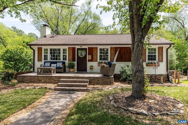 ranch-style home with a porch, a chimney, and a shingled roof