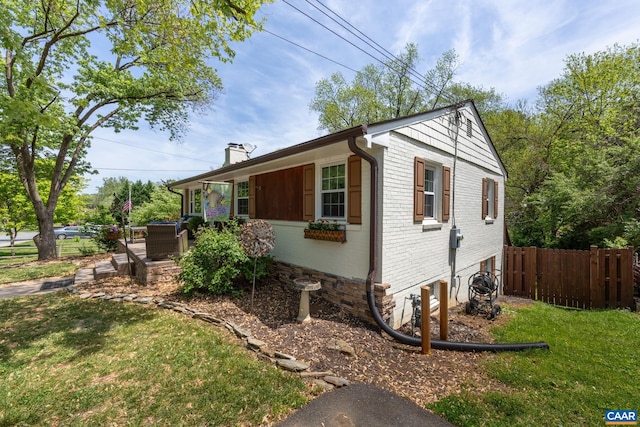 view of side of home with brick siding and a chimney