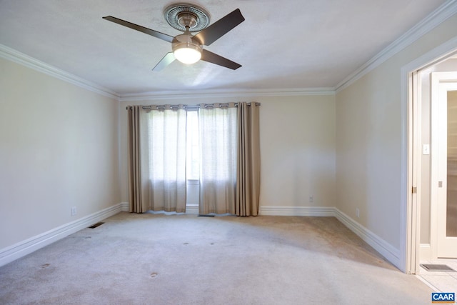 carpeted empty room with ceiling fan, ornamental molding, and baseboards