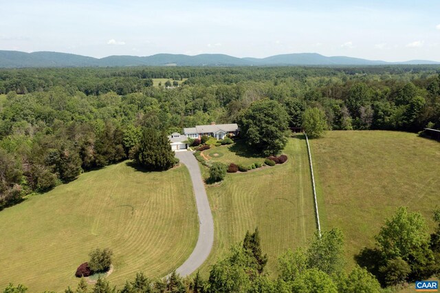 birds eye view of property with a wooded view and a mountain view