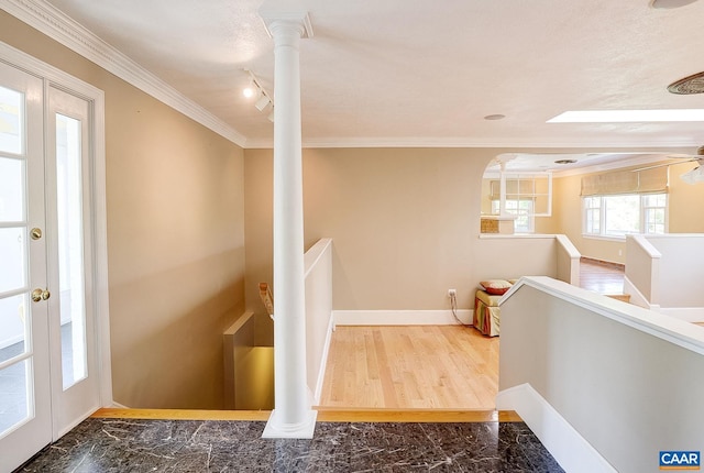 hall featuring marble finish floor, ornamental molding, baseboards, and an upstairs landing