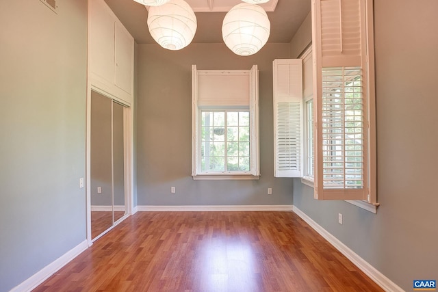 unfurnished room featuring baseboards and wood finished floors