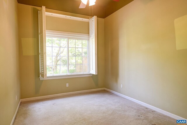 spare room featuring carpet floors, a ceiling fan, and baseboards