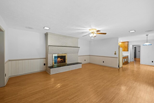 192 Sandy Ridge Rd, Waynesboro, VA 22801 - unfurnished living room featuring wainscoting, ceiling fan, light wood finished floors, and a fireplace