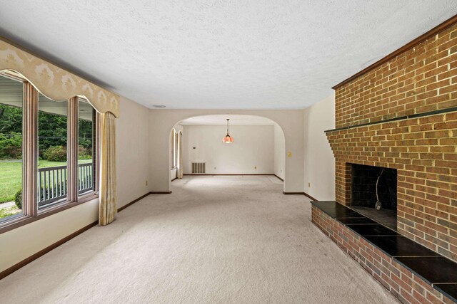 192 Sandy Ridge Rd, Waynesboro, VA 22801 - unfurnished living room with light colored carpet, arched walkways, a textured ceiling, and a fireplace