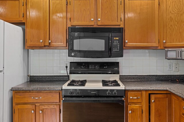 192 Sandy Ridge Rd, Waynesboro, VA 22801 - kitchen featuring black microwave, gas range, freestanding refrigerator, decorative backsplash, and dark countertops