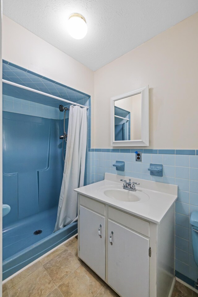 192 Sandy Ridge Rd, Waynesboro, VA 22801 - full bath featuring tile walls, vanity, a stall shower, a textured ceiling, and wainscoting