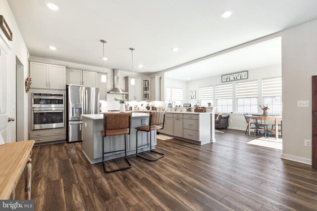 2089 Whithorn Hl, Jeffersonton, VA 22724 - kitchen featuring stainless steel appliances, wall chimney range hood, gray cabinetry, a kitchen island, and a breakfast bar area