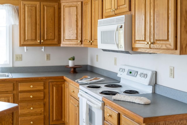 49 Bridgeport Dr, Waynesboro, VA 22980 - kitchen with white appliances, brown cabinetry, and a sink