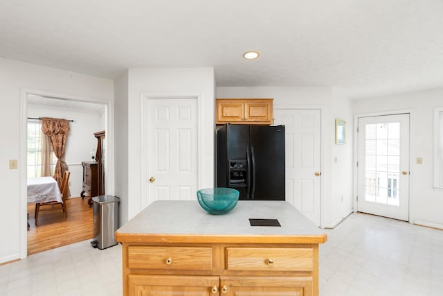 49 Bridgeport Dr, Waynesboro, VA 22980 - kitchen with black fridge with ice dispenser, light flooring, light countertops, baseboards, and a center island
