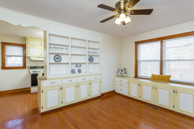 kitchen with ceiling fan, white range with electric cooktop, plenty of natural light, and light hardwood / wood-style floors