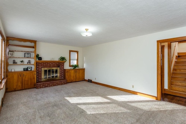 unfurnished living room with light carpet, a brick fireplace, and a textured ceiling